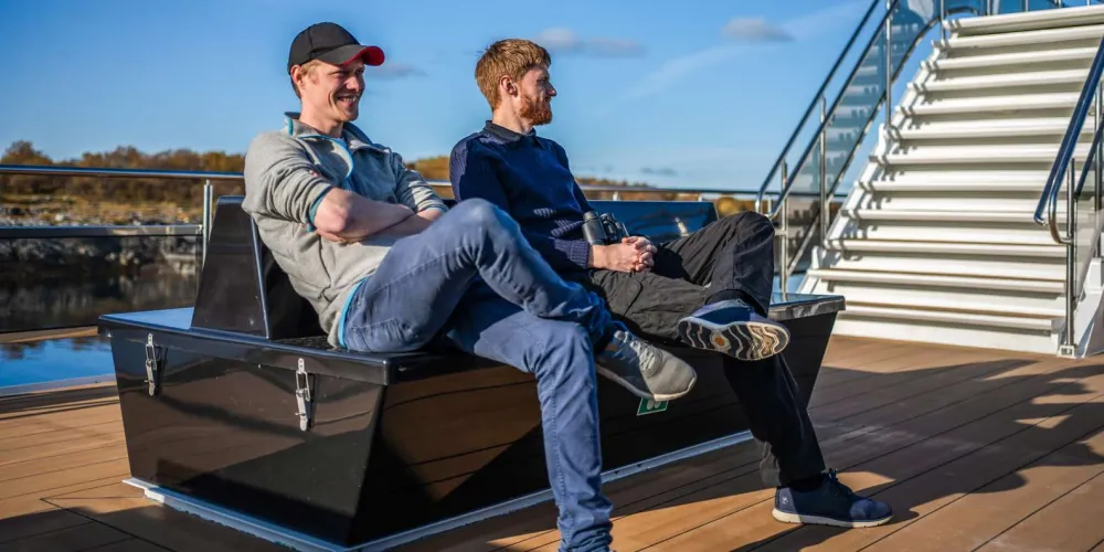 Passengers relaxing on the panoramic deck loungers of the Trollfjord boat