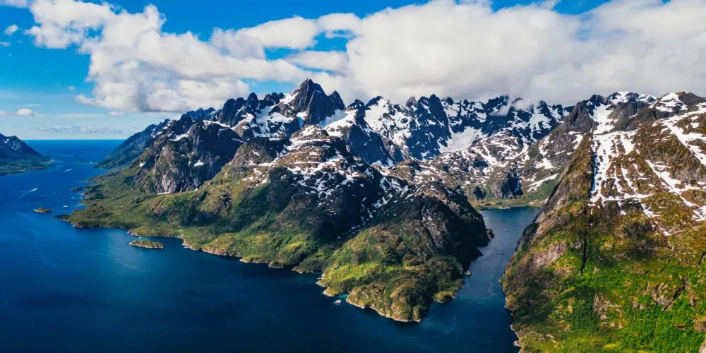Snow-capped mountains rising straight from the sea at the mouth of Trollfjord