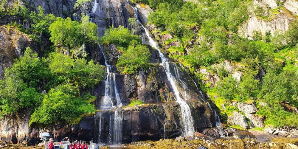 A waterfall tumbling into the fjord as the RIB passes below