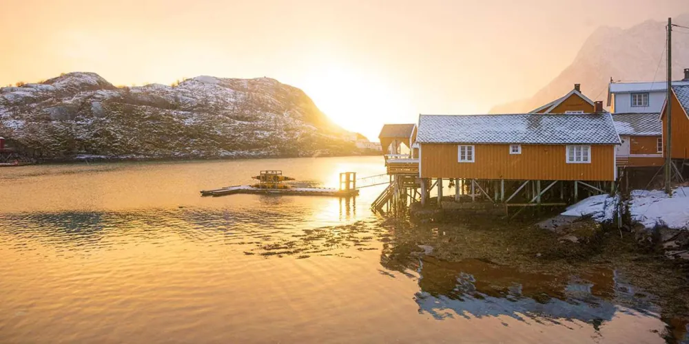 Golden-hour light on a waterside rorbu at Sakrisoy